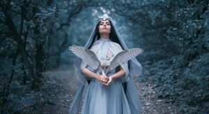 A mystical woman holds an owl.